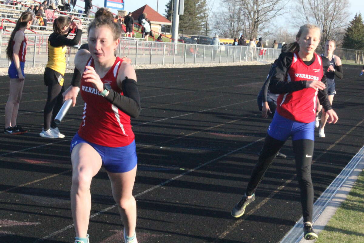 Chippewa Hills Sarah Storey (left) takes off after getting the baton from Natalie Gibson (right) in action last week.