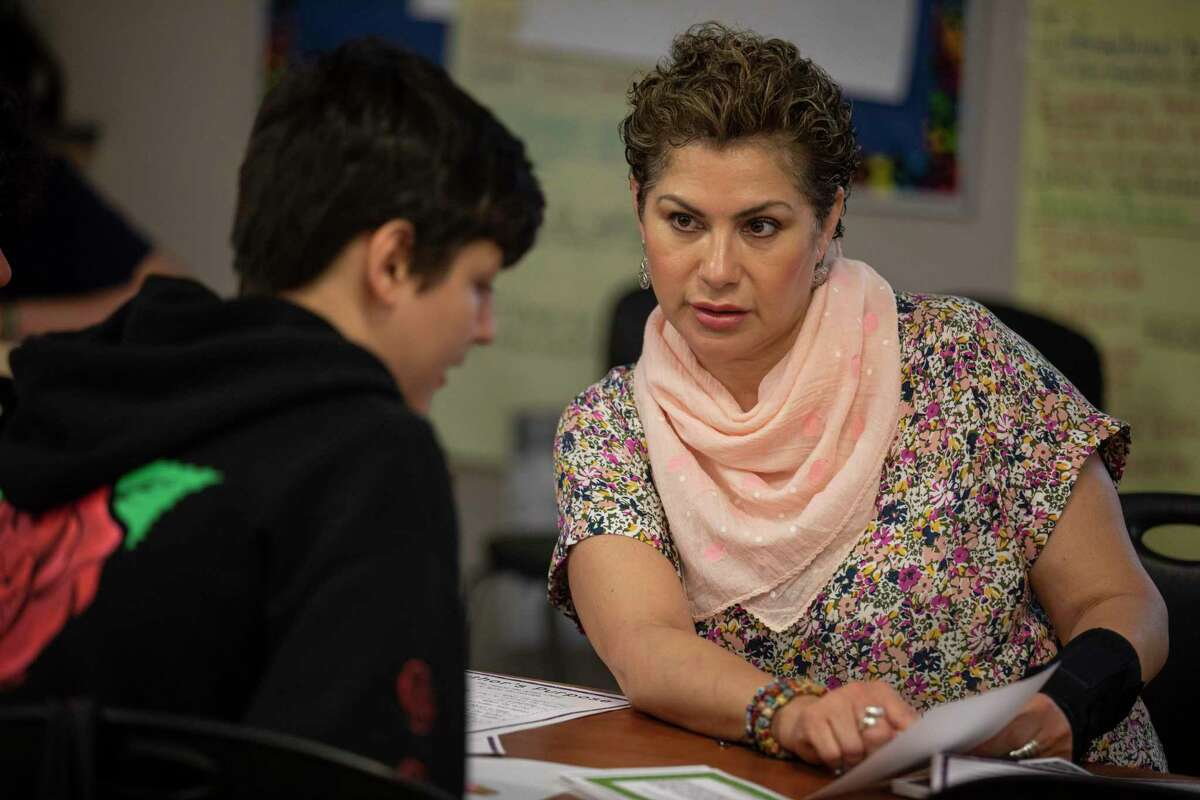 Anita Pickett works with her eight grade students on a reading comprehension activity during fifth period at Somerset Junior High School in Von Ormy, Texas, Wednesday, May 4, 2022.