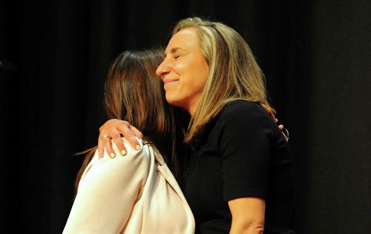 Western Middle School science teacher Tyler Mecozzi, facing left, hugs her nominator Michelle Giorlando DeRosa during the Distinguished Teachers Awards Ceremony at Central Middle School in Greenwich, Conn., on Thursday May 5, 2022.