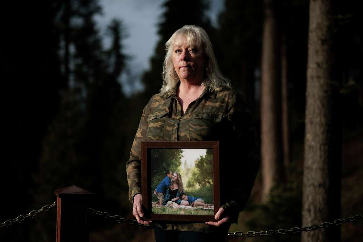 Betsy Hurst-Younger holds a photo of her daughter and grandchildren in Sugar Pine, an unincorporated area of Madera County. Hurst’s 33-year-old daughter died from COVID last year.