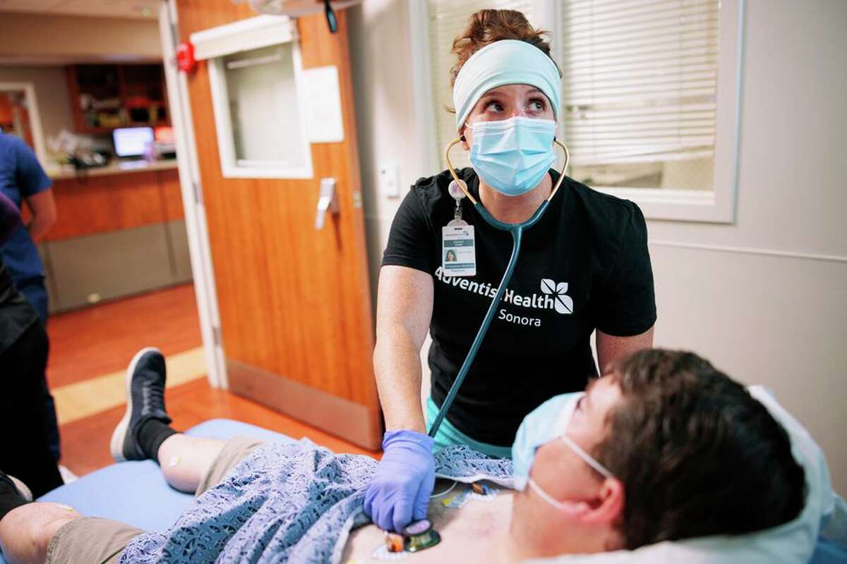 Dr. Sarah Dunn examines a patient at Adventist Health Sonora’s emergency department in Sonora (Tuolumne County). The hospital witnessed COVID surges in the past two years that sometimes filled all of its beds.