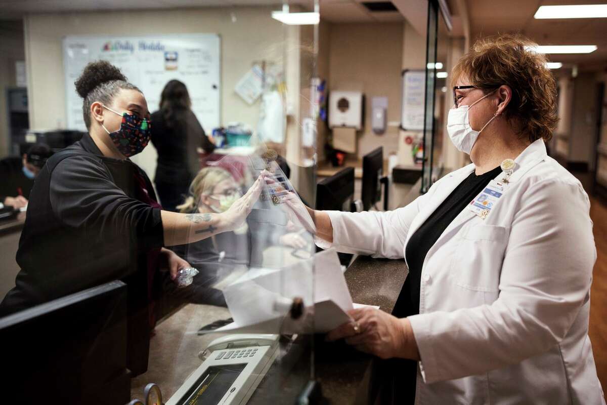 Critical care nurse manager Kim Diaz (right) high-fives certified nurse assistant Mallay Crownover at Adventist Health in Sonora. The health care center had to expand its intensive care unit during the pandemic.