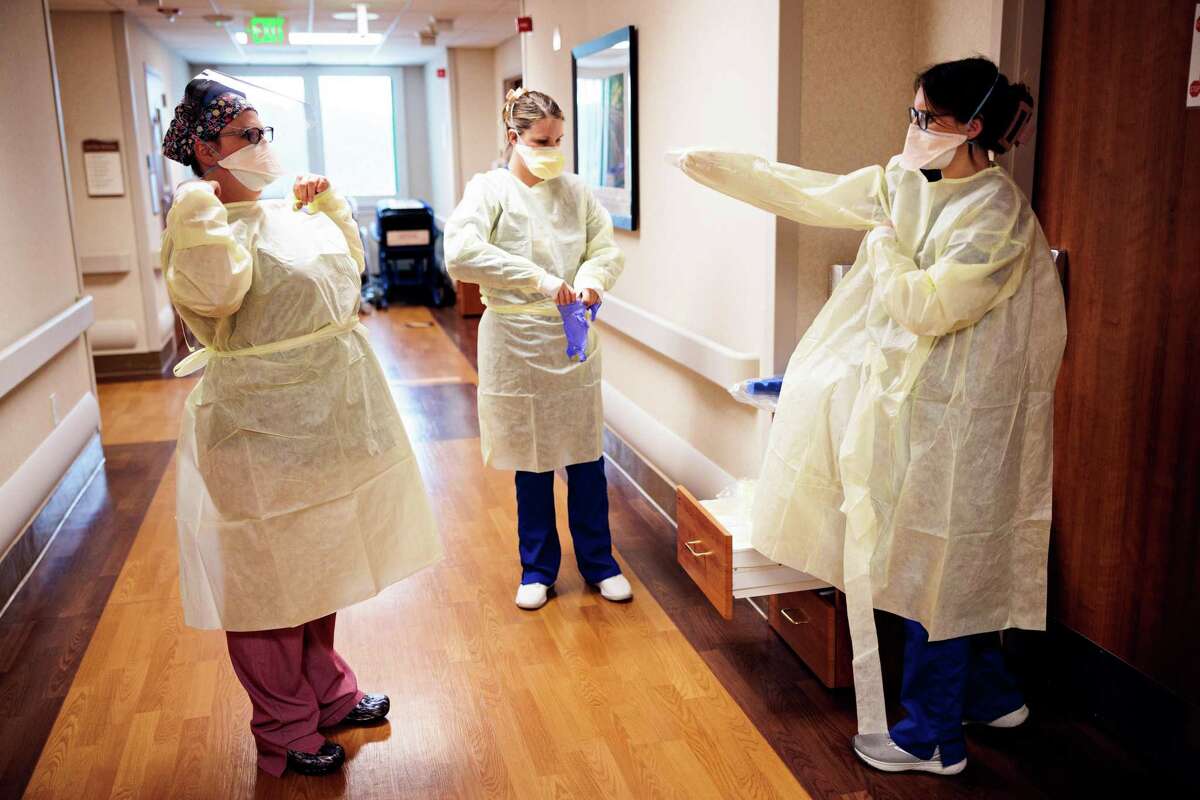 As COVID cases continue to surge in Bay Area, health officials urge people to wear masks and be more cautious. Nurse Kathryn Gray (left) and nursing students Nicole Avrit and Laci Blount get ready to check on a COVID patient at Adventist Health hospital in Sonora. California is nearing a cumulative 90,000 COVID deaths since the start of the pandemic.