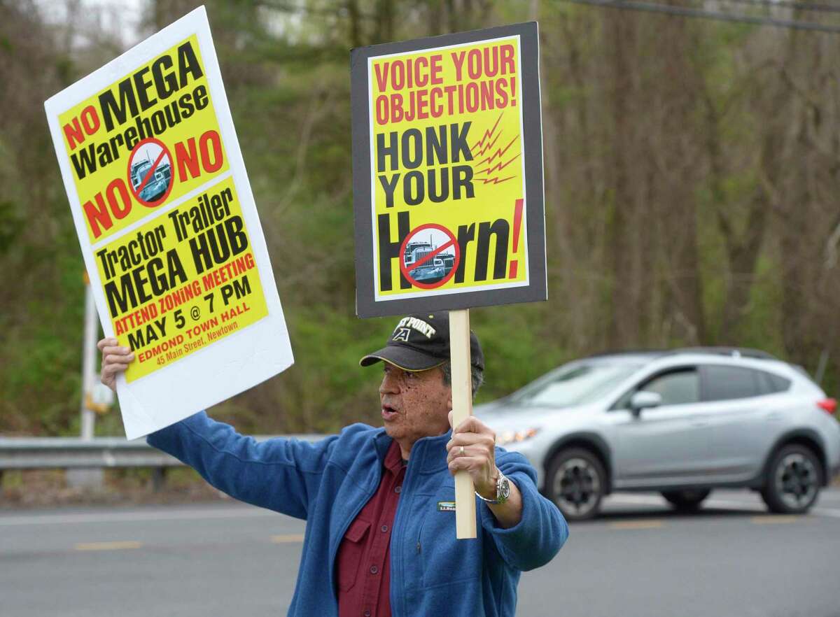 Tulio Lopez, of Newtown, takes part in a protest at Mount Pleasant Road and Hawleyville Road over plans to build an 8-acre warehouse on 100 acres of land at I-84’s Exit 9. Wednesday, May 4.