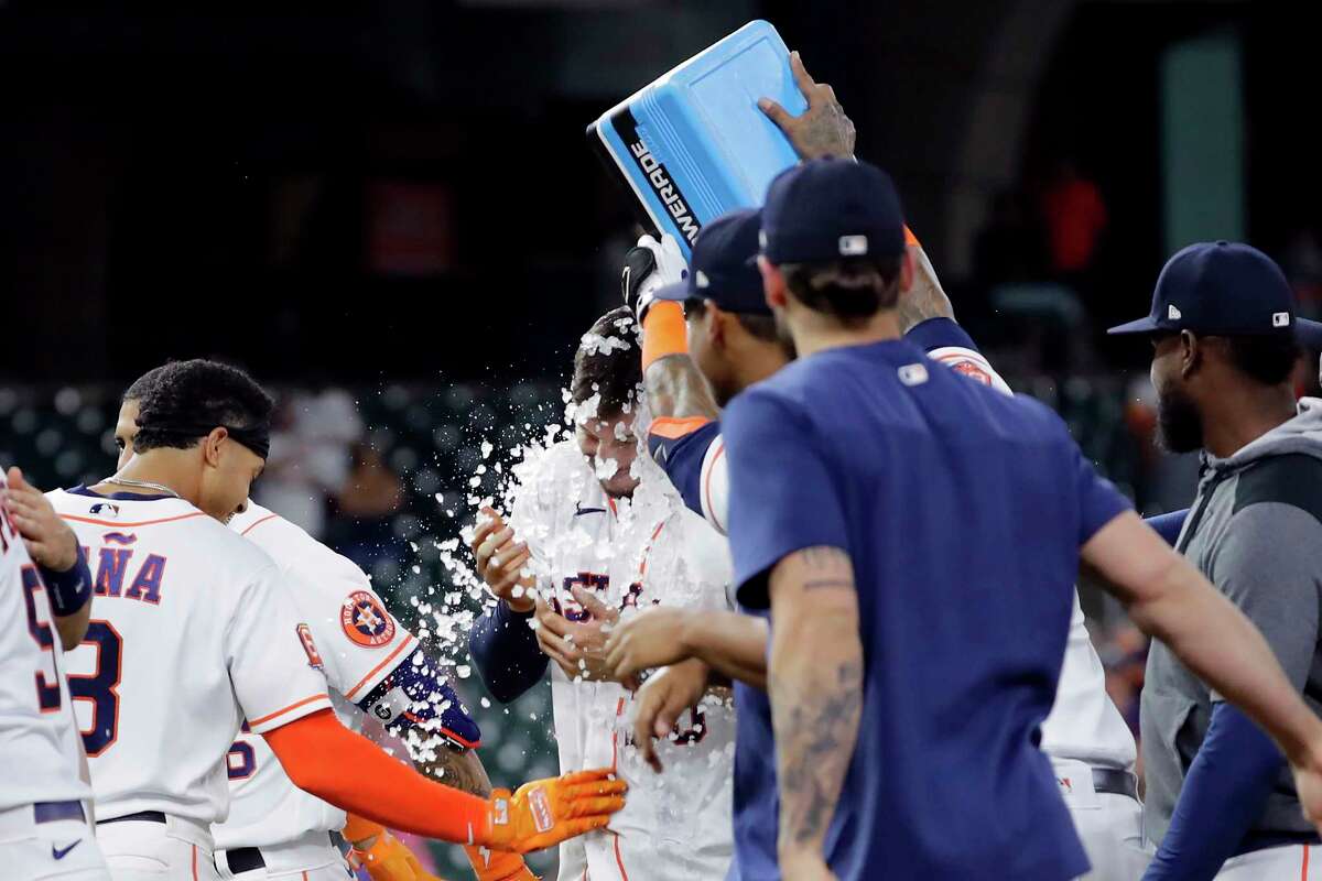 Houston Astros' Kyle Tucker, middle, gets an ice bath after his single drove in the winning run against the Detroit Tigers in in a baseball game Thursday, May 5, 2022, in Houston. (AP Photo/Michael Wyke)