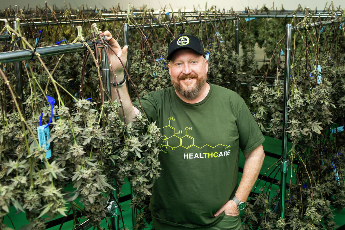 Emerald Fire Provisioning Center Co-owner and President John Siggerud stands alongside racks of cannabis plants Thursday, May 5, 2022 at the facility in Coleman.
