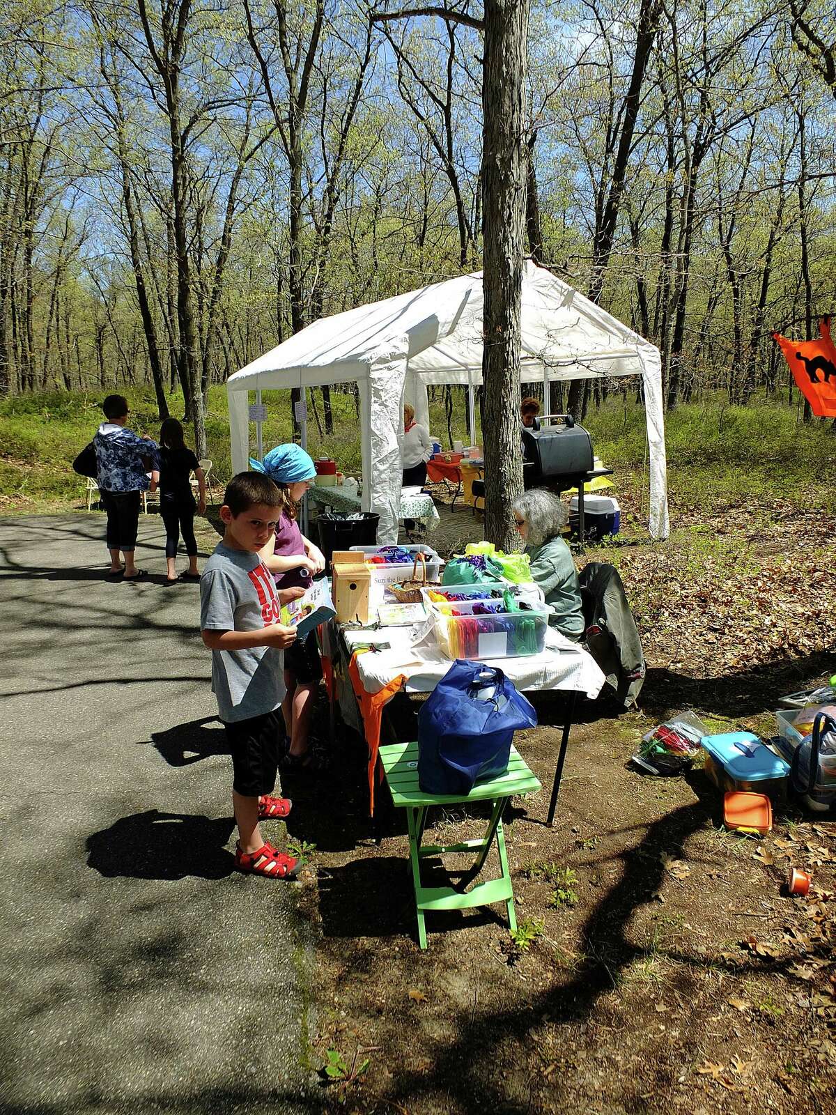 Visitors to the Lady’s Slipper Festival at the Huron County Nature Center peruse the offerings of arts and crafts vendors set up along the trail system during the festival.