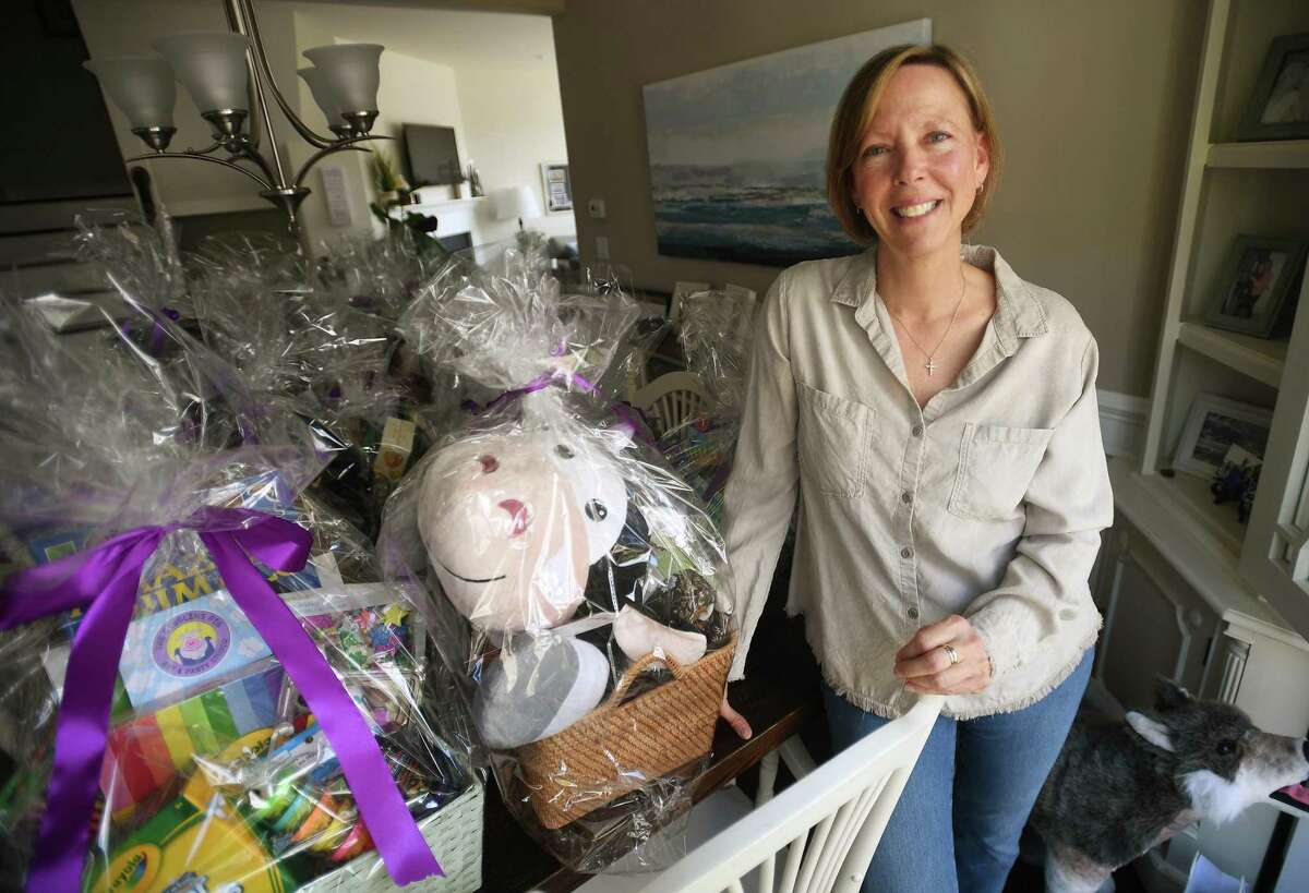 Ruth's House Founder and President Jeanne Korman readies silent auction prizes for Monday's Ruth's House Charity Golf Classic fundraiser at her home in Shelton, Conn., on Thursday, May 5, 2022.