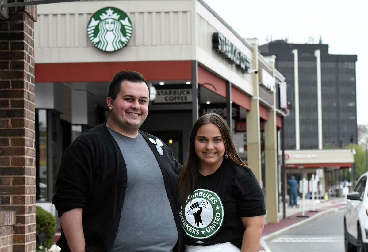 Starbucks employees Jacob Evans, left, and Alexandra Yeager, right, stand outside the Stuyvesant Plaza Starbucks where they are trying to organize the store into a union shop on Friday, May 6, 2022, in Guilderland, N.Y.