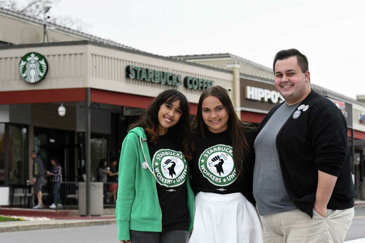 Starbucks employees Precious Melendez, left, Alexandra Yeager, center, and Jacob Evans, right, stand outside the Stuyvesant Plaza Starbucks where they organized into a union shop on Friday, May 6, 2022, in Guilderland, N.Y.