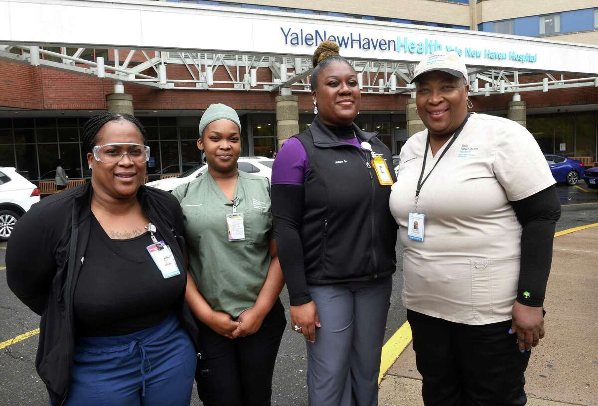 From left, Dreialice Adkins, Tara Ann Labone and Alisa Simon are photographed with their mother, Marjorie Telemacque, in front of Yale New Haven Hospital, where they all work.