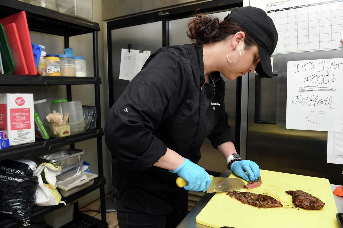 Amanda Cesare slices chimichurri steak at Amanda’s Healthy Cooking in Guilford on May 6, 2022.