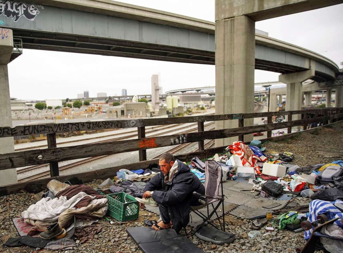 加布是奥克兰庞大的伍德街无家可归者营地的居民，7月，他坐在一座木桥上。