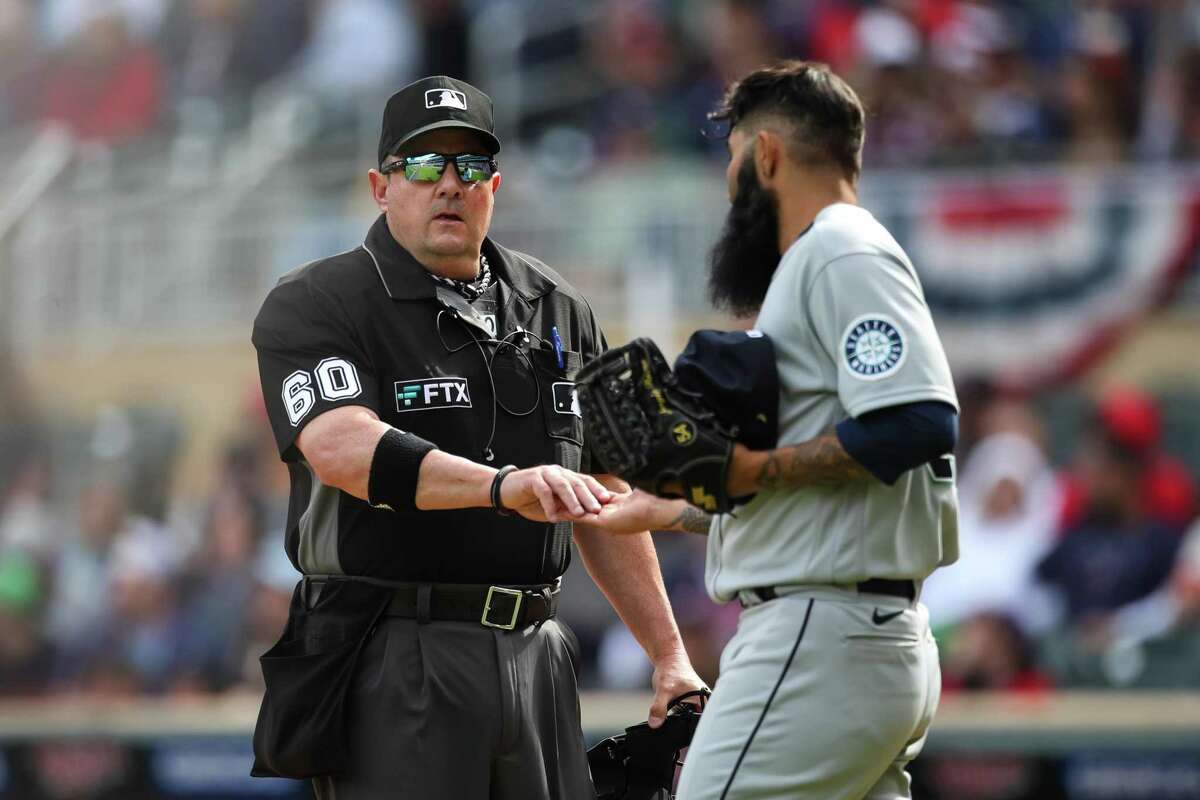 MINNEAPOLIS, MN - APRIL 09: Umpire Marty Foster #60 checks the throwing hand of Sergio Romo #54 of the Seattle Mariners for foreign substances after pitching to the Minnesota Twins in the seventh inning of the game at Target Field on April 9, 2022 in Minneapolis, Minnesota. The Mariners defeated the Twins 4-3. (Photo by David Berding/Getty Images)