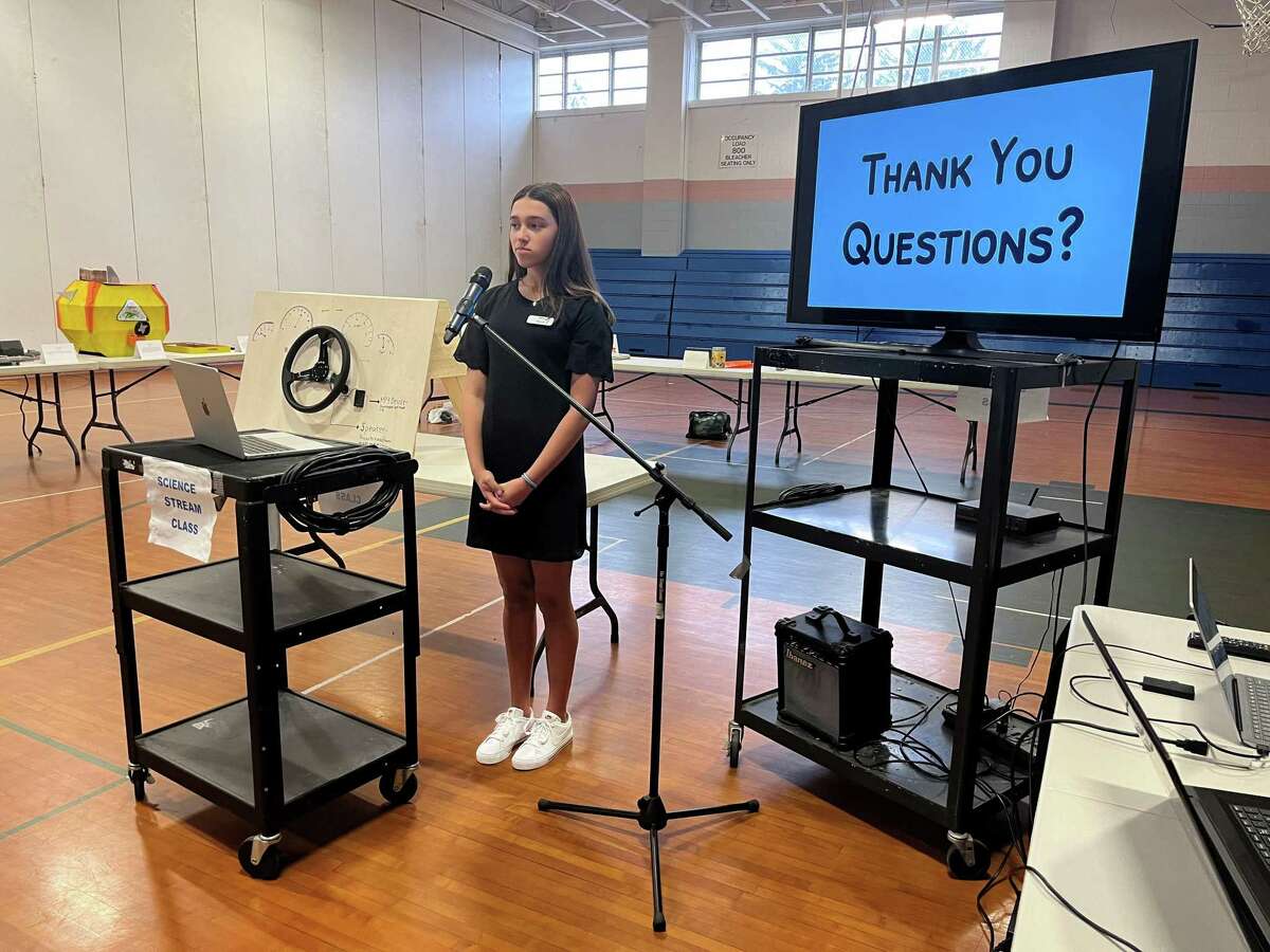All Saints Catholic School eighth-grade student Alexis Adcock presents her capstone project on May 4, 2022 in the school gymnasium.  She invented The Happy Horn, a car horn with a "nicer tone" for drivers to use in traffic.