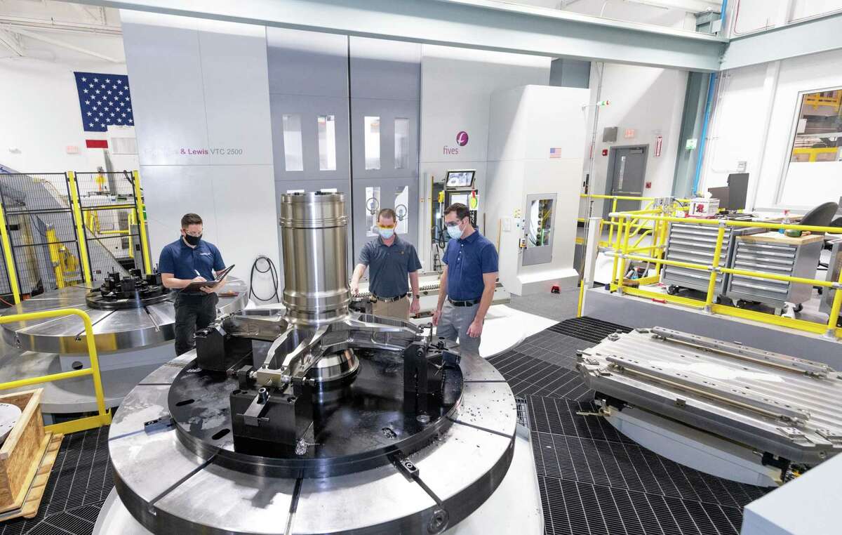 Sikorsky manufacturing engineers Jason Pratts and Ryan Patry review a lower rotor hub alongside Pete Germanowski (L-R), chief engineer of Sikorsky's prototype for the U.S. Army's Future Attack Reconnaissance Aircraft program for an armed scout helicopter, in May 2022 at the Lockheed Martin subsidiary's headquarters plant in Stratford.