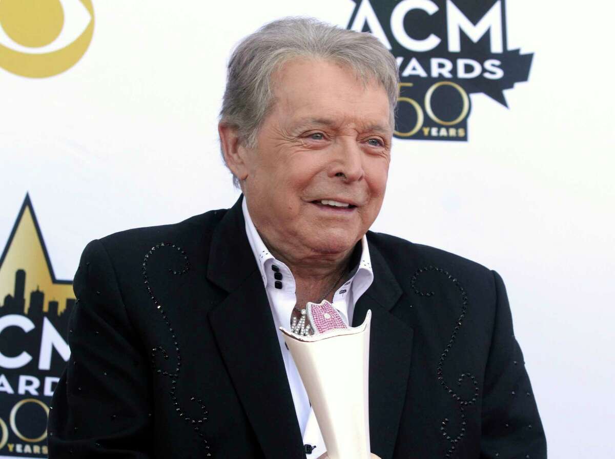 FILE - Mickey Gilley poses with the Triple Crown Award on the red carpet at the 50th annual Academy of Country Music Awards at AT&T Stadium in Arlington, Texas, April 19, 2015. Gilley, whose namesake Texas honky-tonk inspired the 1980 film “Urban Cowboy,” and a nationwide wave of Western-themed nightspots, died Saturday, May 7, 2022, at age 86. (Photo by Jack Plunkett/Invision/AP, File)