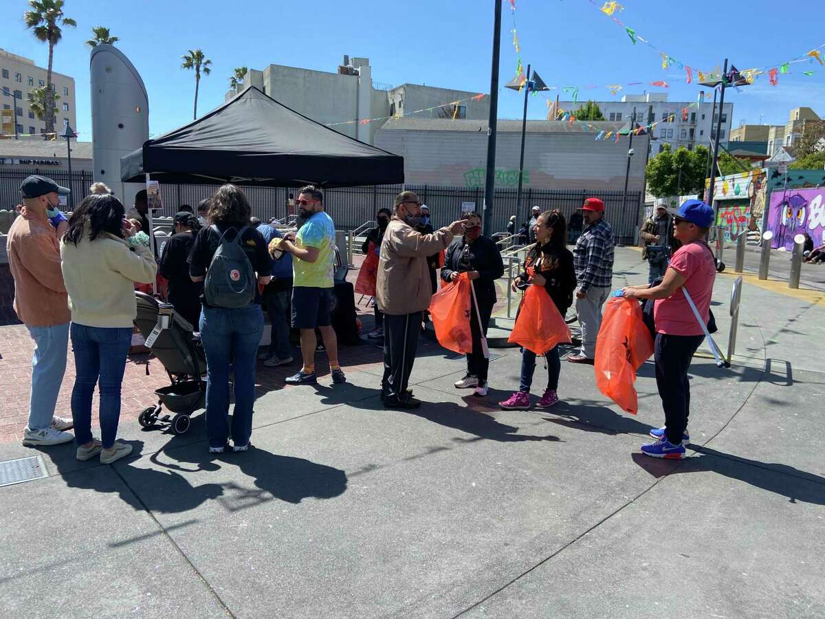 Los voluntarios recolectan suministros para limpiar las calles en el lanzamiento del programa de recuperación económica en el Distrito Cultural Latino Calle 24.