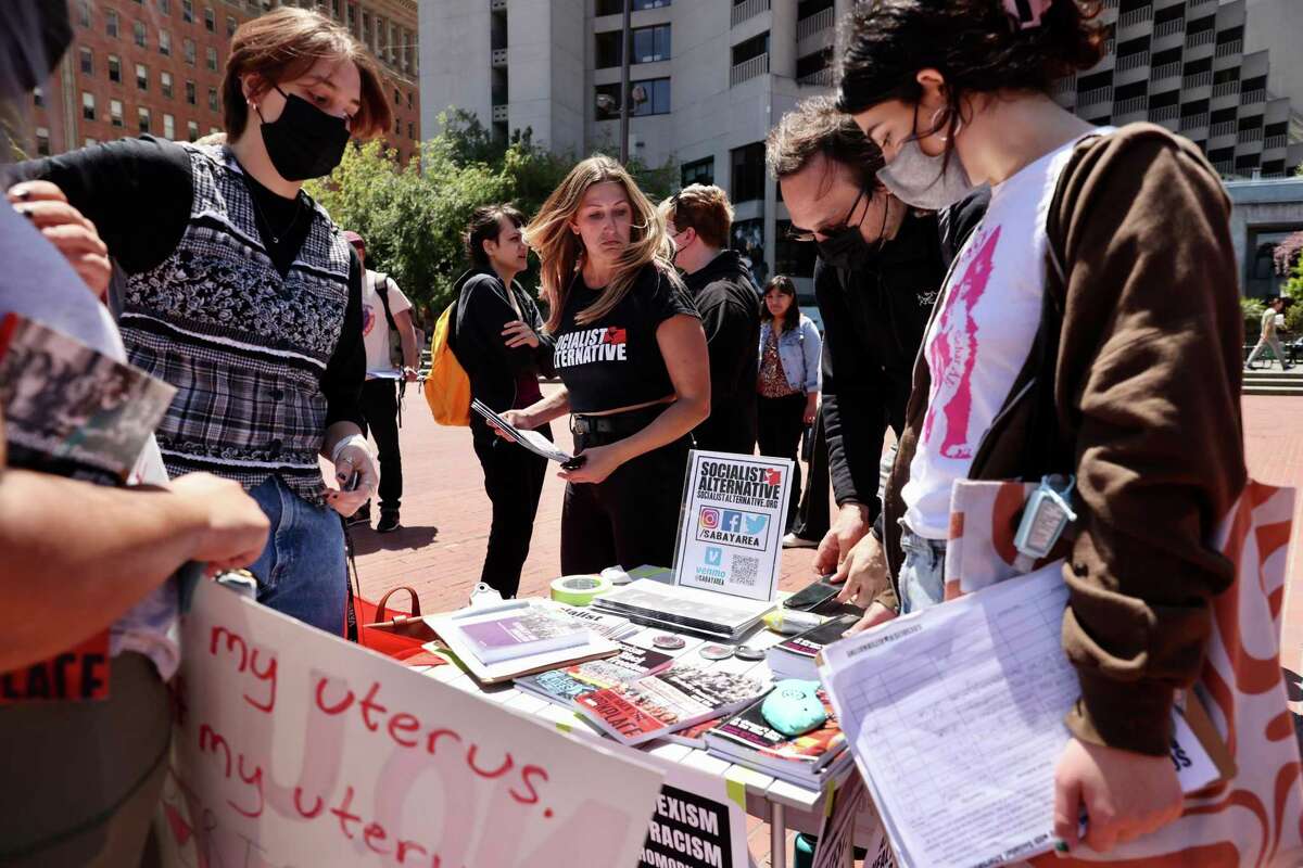 Victoria Gaston (center) of Socialist Alternative holds literature during a rally supporting Roe v. Wade.