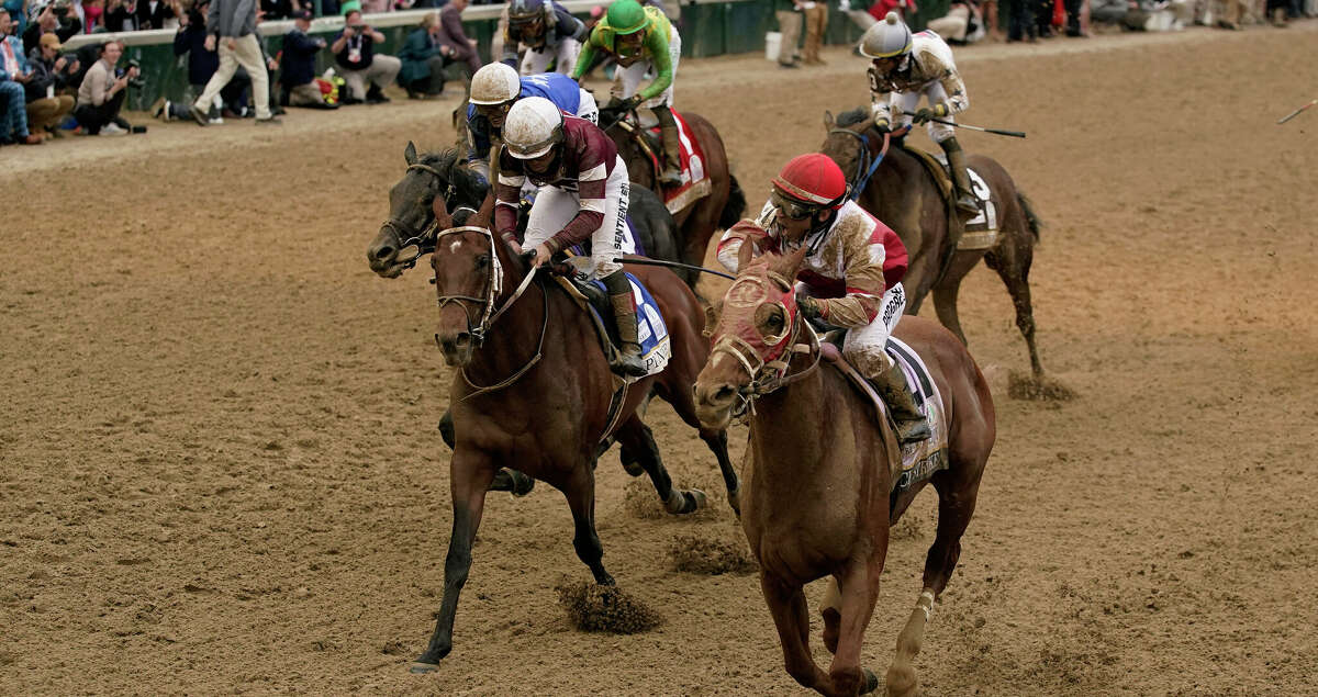 Rich Strike, right, with Sonny Leon aboard, crosses the finish line to win the 148th running of the Kentucky Derby horse race at Churchill Downs Saturday, May 7, 2022, in Louisville, Ky. (AP Photo/Jeff Roberson)