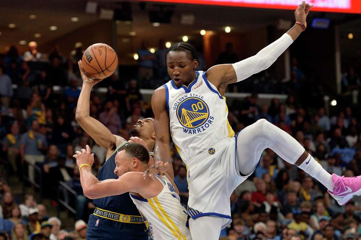 Memphis Grizzlies guard De'Anthony Melton struggles for control of the ball against Golden State Warriors guard Stephen Curry and forward Jonathan Kuminga (00) during the second half during Game 2 of a second-round NBA basketball playoff series Tuesday, May 3, 2022, in Memphis, Tenn. (AP Photo/Brandon Dill)