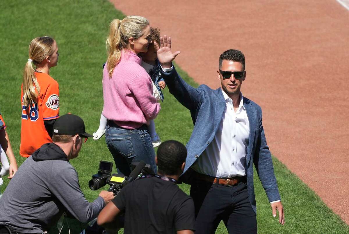 Retired Giants catcher Buster Posey, a member of three championship teams, waves to fans.