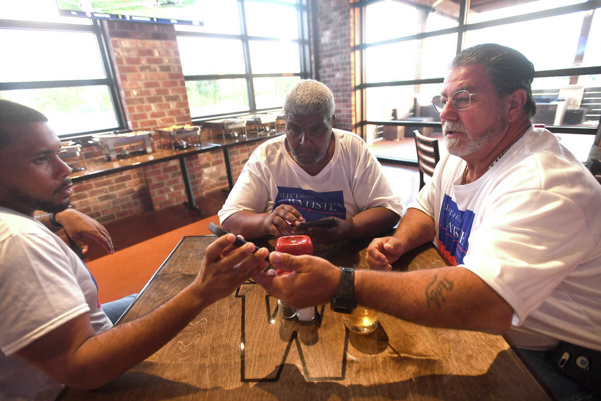 Port Arthur Mayoral candidate Floyd Batiste looks over first numbers with nephew Timothy O'Neal and Chuck Vincent during an election night watch party Saturday. Photo made Saturday, May 7, 2022. Kim Brent/The Enterprise