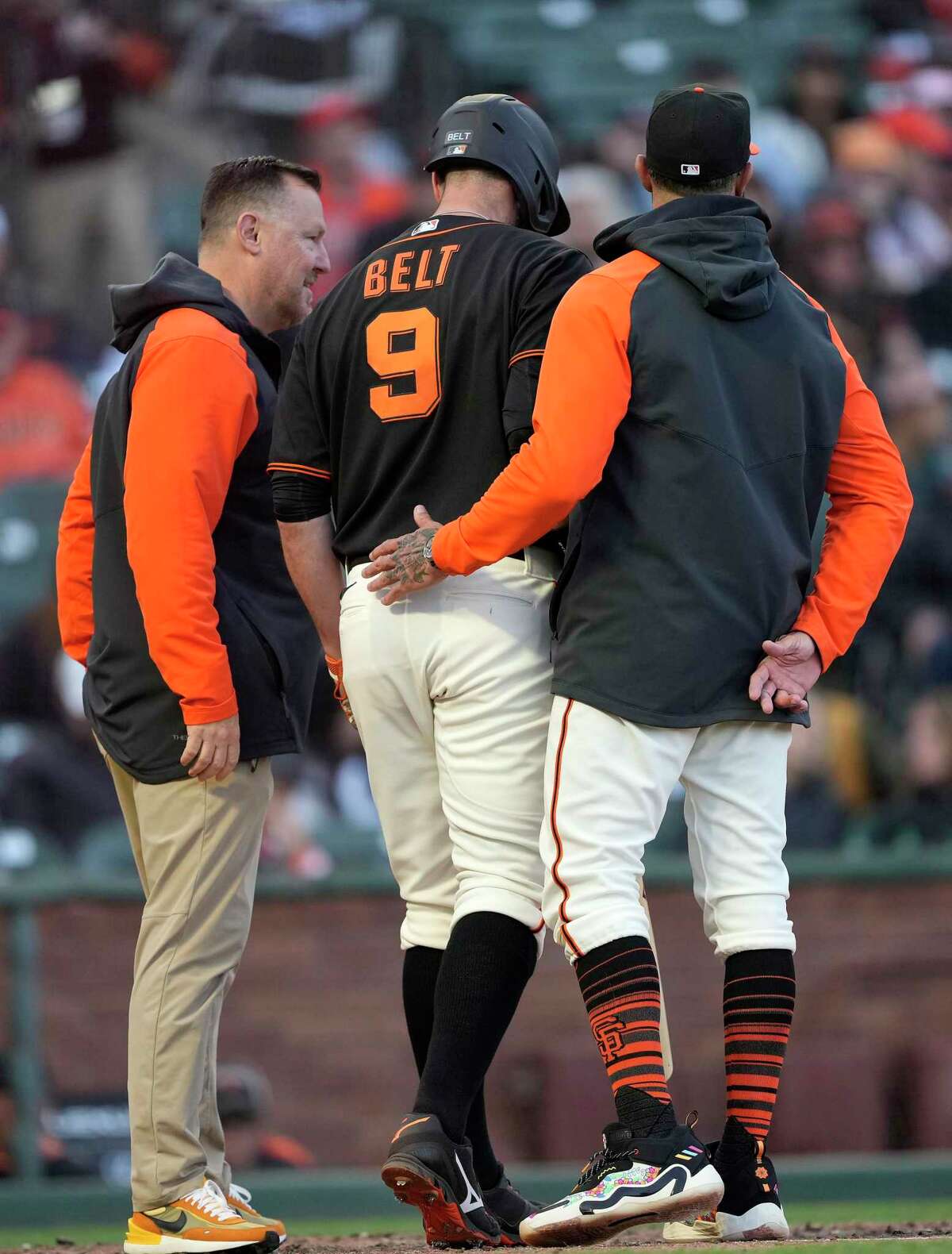 San Francisco Giants' Brandon Belt (9) leaves the baseball game with a team trainer and manager Gabe Kapler, right, during the eighth inning against the St. Louis Cardinals on Saturday, May 7, 2022, in San Francisco. (AP Photo/Tony Avelar)