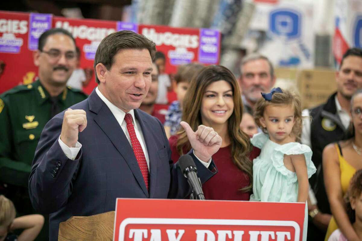 Florida Governor Ron DeSantis, Florida First Lady Casey DeSantis, holding Mamie DeSantis is shown right, announced a sales tax cut of more than $1 billon dollars during an event at Sam's Club in Ocala, Fla., Friday, May 6, 2022. Floridians will save on items ranging from diapers and gasoline to auto racing tickets and energy efficient appliances under the tax cut package signed into law. (Alan Youngblood/Ocala Star-Banner via AP)