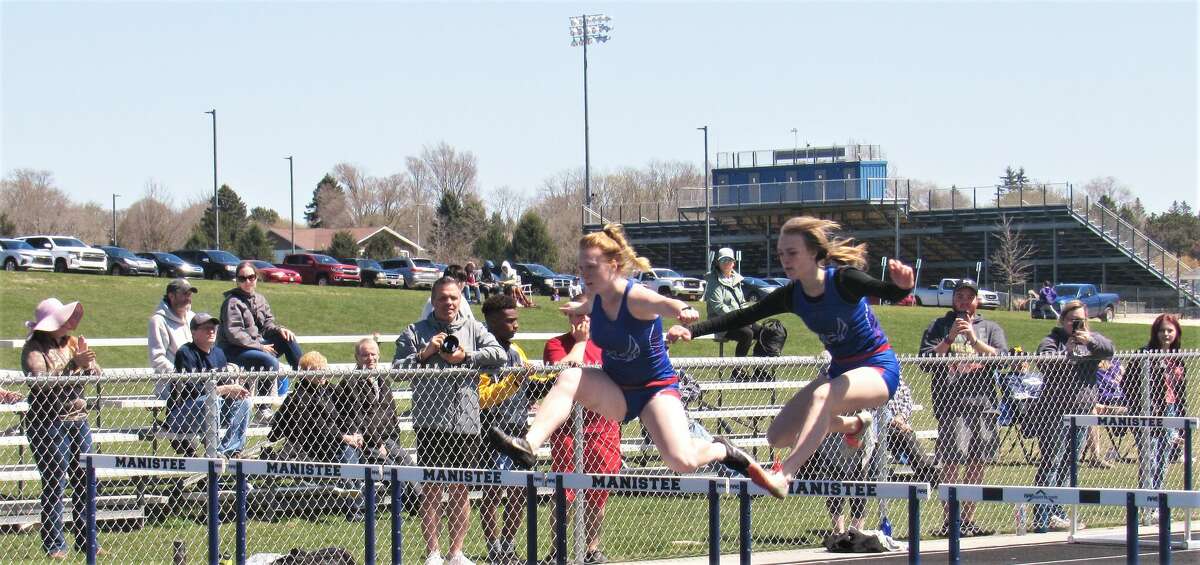 Manistee Catholic Central's Kaitlyn Duke (left) and Maddy Duke compete in the 100 meter hurdle event during the Saber Flash Invitational on Saturday, May 7th at Manistee Community Track. Maddy beat Kaitlyn by .01 seconds. 