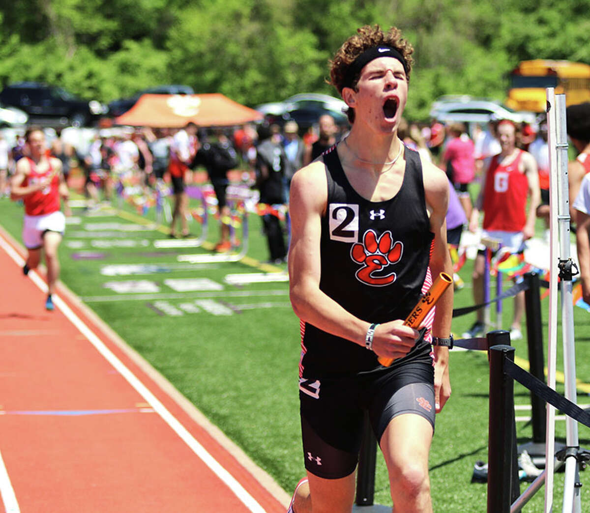 Edwardsville's Geordan Patrylak reacts while crossing the finish line in the leg of the Tigers' winning 4x800 relay Saturday at the Collinsville Invitational.