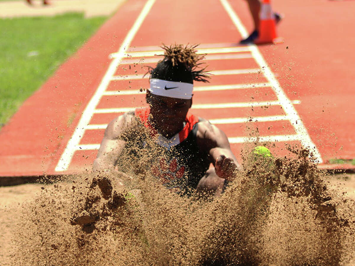 Edwardsville's Jordan Brooks splashes down in the triple jump during the Collinsville Invitational on Saturday at Collinsville.