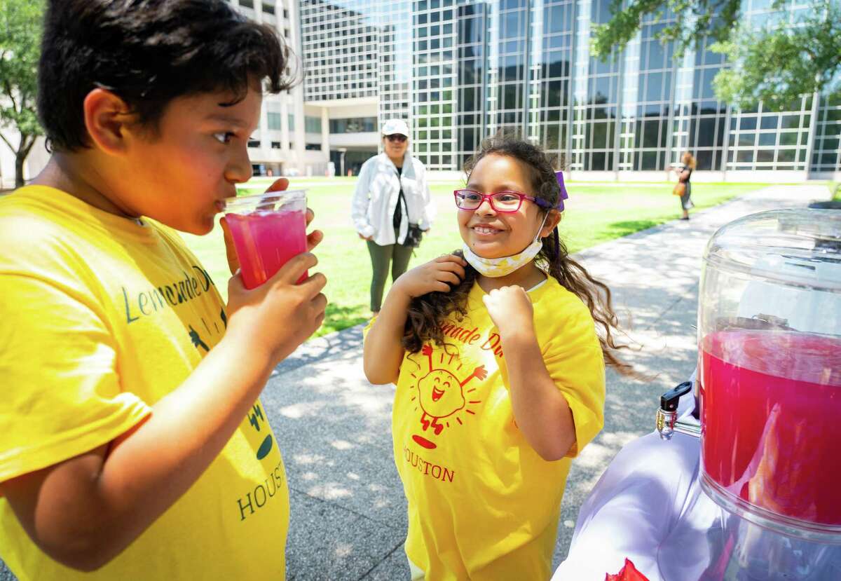 Eight-year-old Ariane Contreras, right, waits to see what her friend thinks of her passion fruit flavored lemonade.