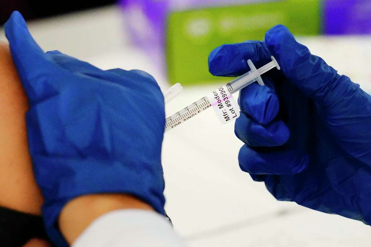 A health worker administers a dose of a Moderna coronavirus vaccine in Pennsylvania. Vaccine makers are studying which combinations will be most effective as society learns to live with COVID.