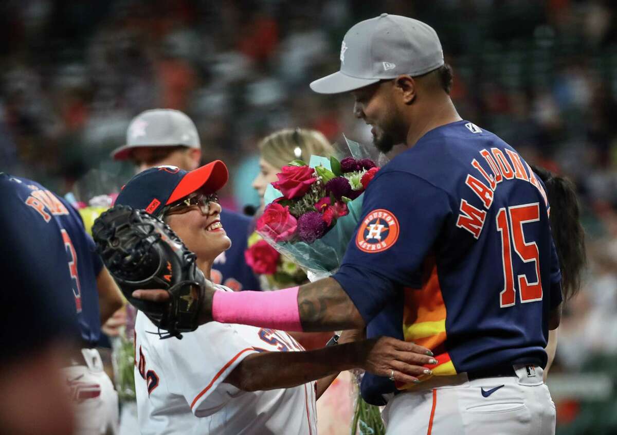 Houston Astros catcher Martin Maldonado (15) hugs his mom Jeanette Valdez after she threw a ceremonial first pitch before during an MLB game against the Detroit Tigers onSunday, May 8, 2022, at Minute Maid Park in Houston.