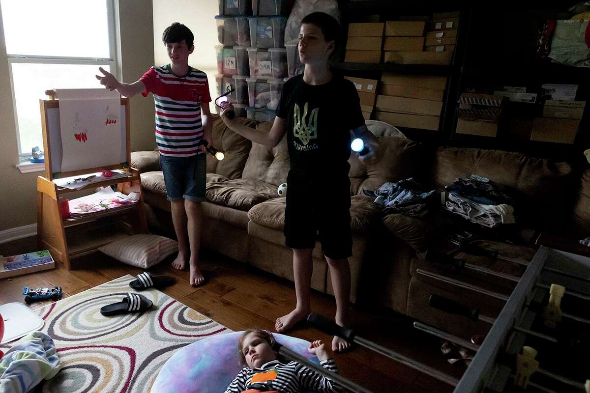 Cousins Bazhen Kovalskyi and Radomyr Kovalskyi play video games while Radomyr’s younger sister, Zoriana, lays on the floor watching them. Bazhen Kovalskyi and his sister Sasha escaped Ukraine via Poland to come live with their family in Texas.