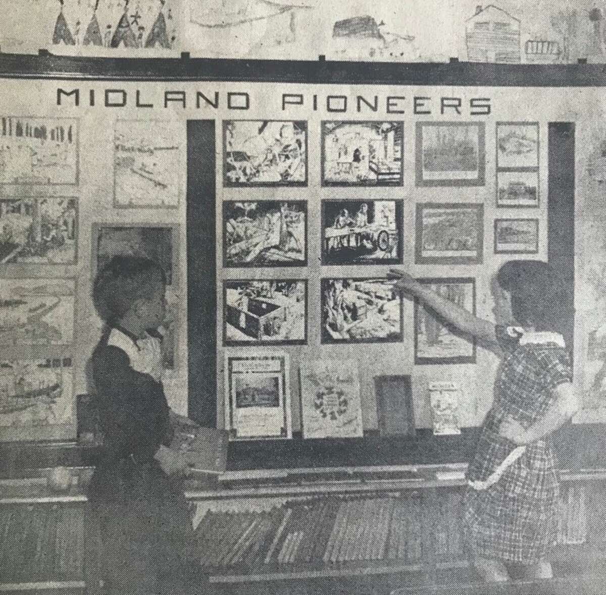 Posters to illustrate phases of early Midland life are shown with State Street School third graders Bruce Altman, left, and Lois Winslow.  Nov 1950