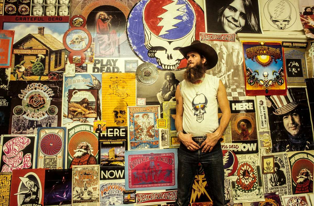 A Deadhead poses in front of Grateful Dead posters at a Haight-Ashbury apartment in January 1980 in San Francisco.