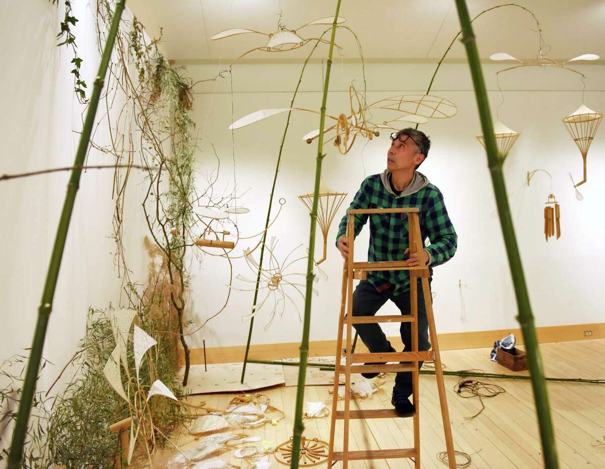 Japanese artist Akinori Matsumoto assembles his exhibit "Sound Garden" at Greenwich Library's Flinn Gallery in Greenwich, Conn. Sunday, May 8, 2022. Matsumoto's show features handmade objects made of bamboo, wood, paper and metal arranged in a multi-dimensional garden-like environment to delight the senses through motion, shadow play, and sound.