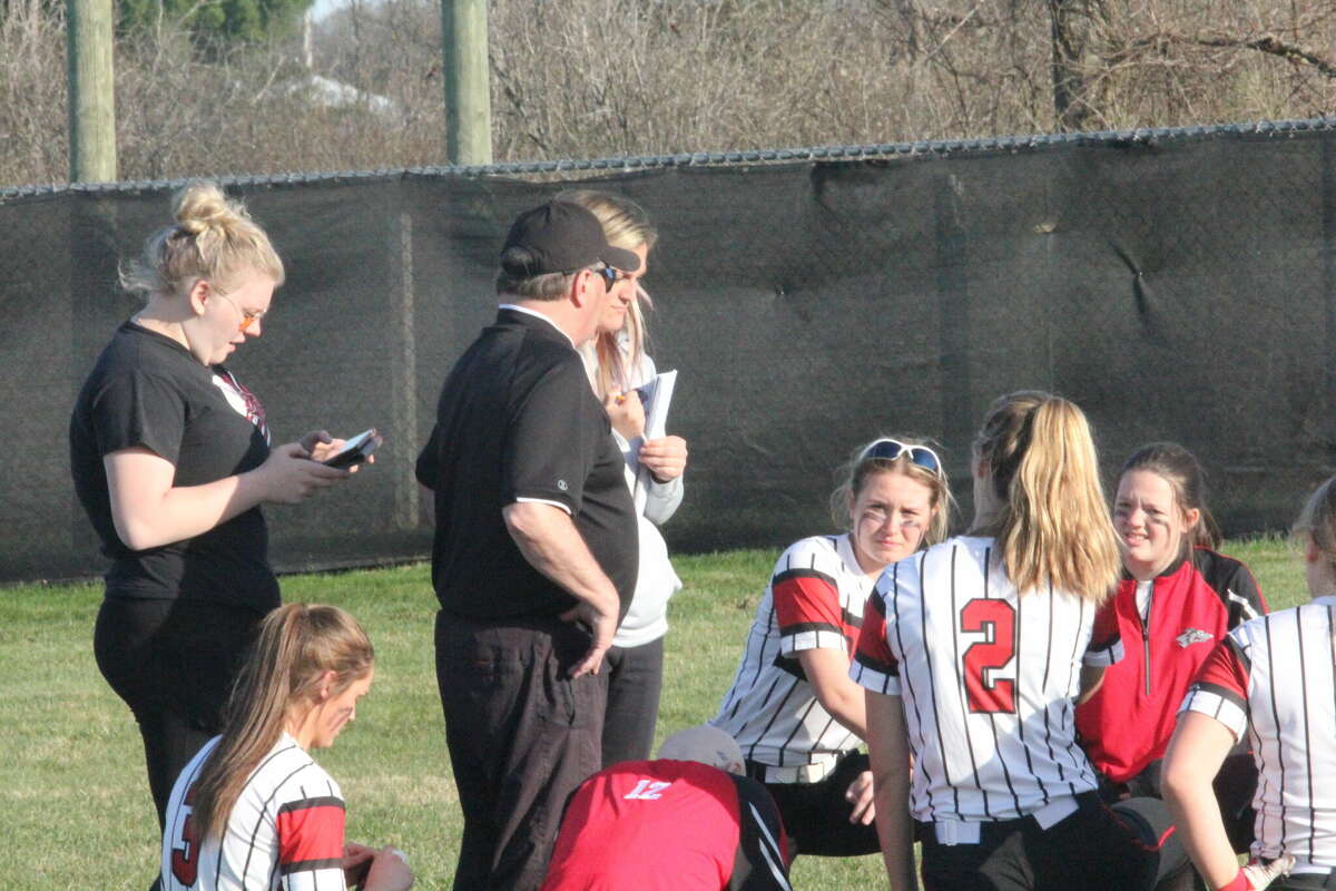 Reed City softball coach Roger Steig (center) talks to his team after a game last week.