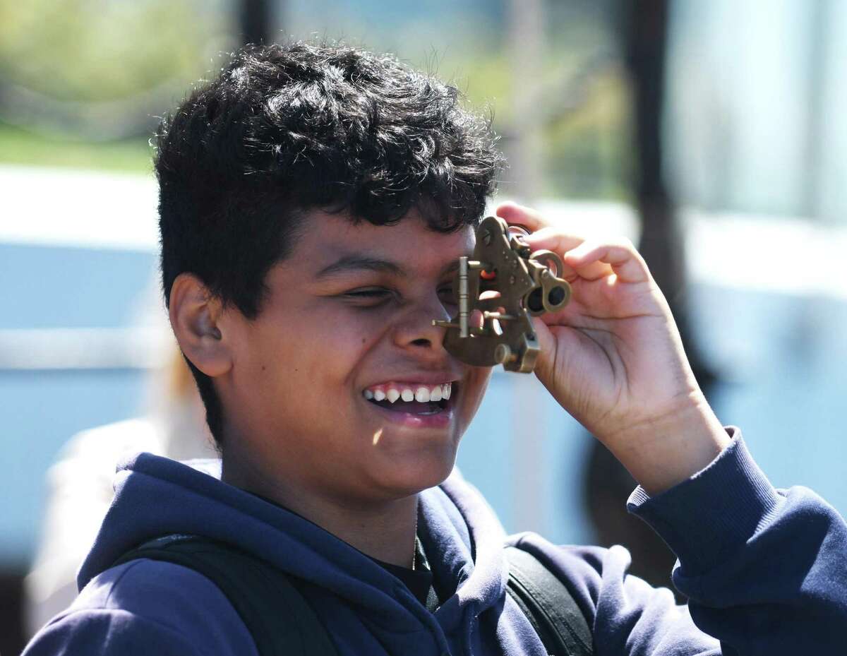 Eighth-grader Eduardo Quintana uses a sextant to determine geographical position while aboard a reproduction of the Amistad slave ship docked at Harbor Point in Stamford, Conn. Monday, May 9, 2022. Eighth grade students toured the ship to kick off the new partnership between Stamford Public Schools and Discovering Amistad. Students learned about the 1839 Amistad slave rebellion and the subsequent Supreme Court decision to free the rebels.