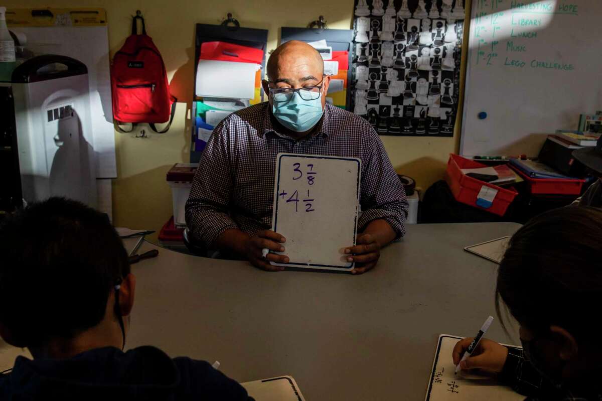 Fourth grade teacher Yusef Aulett wears a mask while teaching a math workshop at Ruth Acty Elementary School in Berkeley, Calif. Monday, March 14, 2022.
