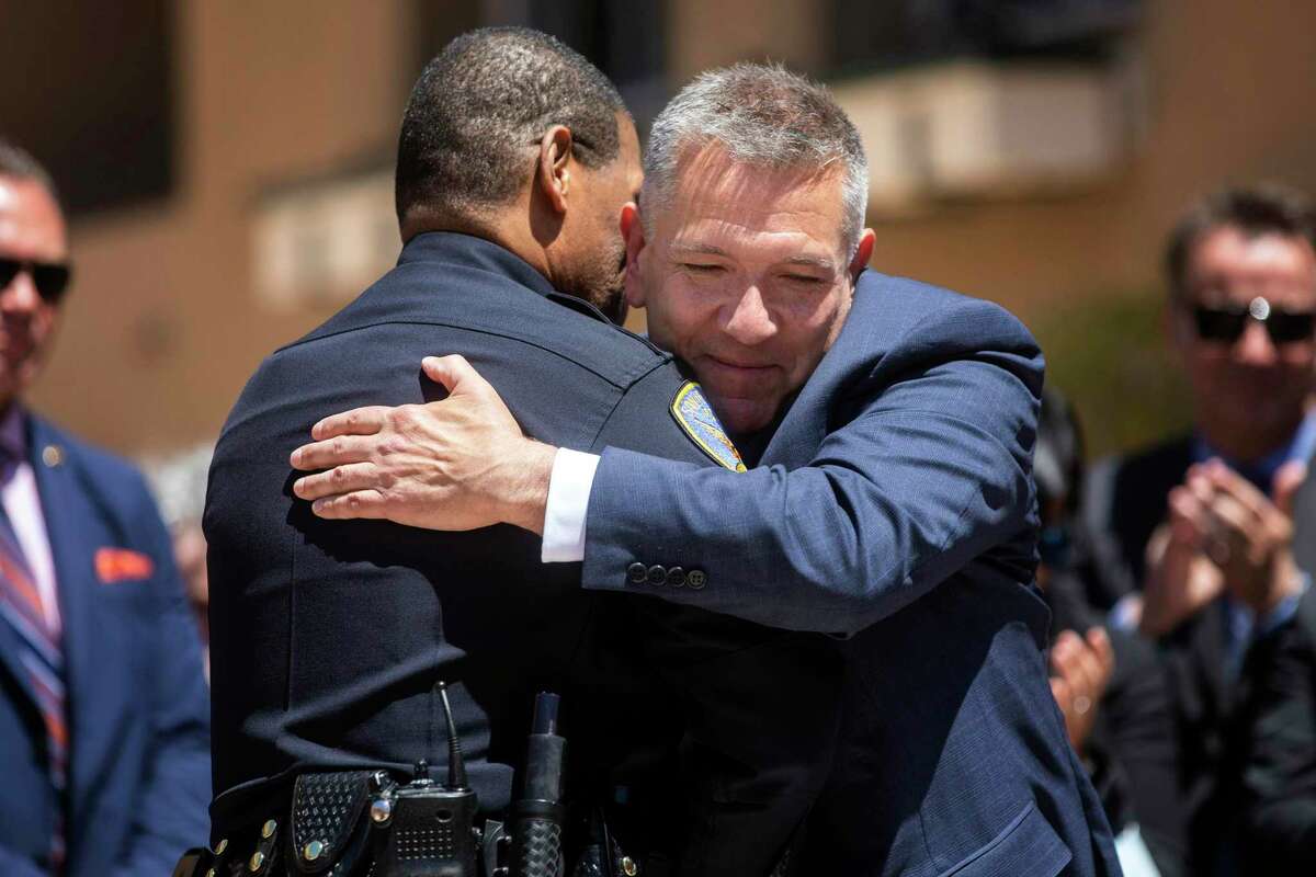SFPD spokesperson Matt Dorsey (right) hugs Police Chief Bill Scott at the Delancey Street Foundation in San Francisco before Dorsey is sworn in Monday as new District Six supervisor .