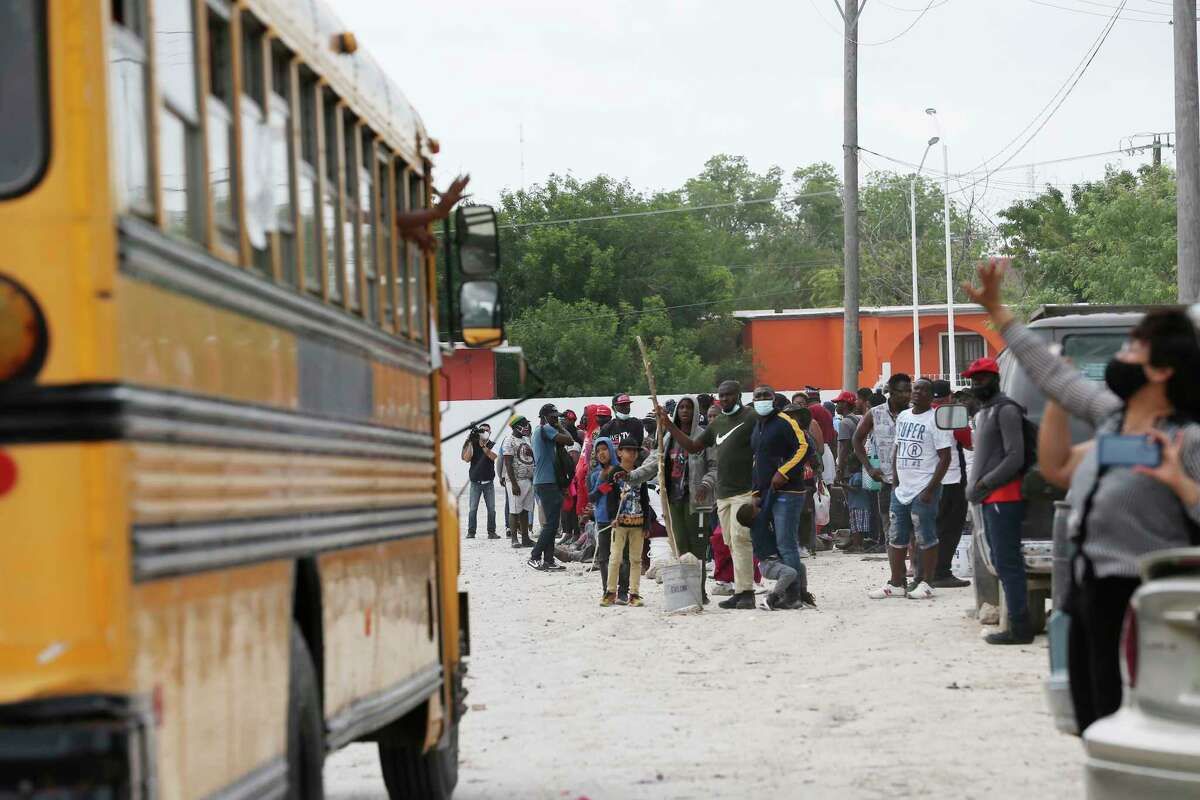 Migrants outside Senda de Vida in Reynosa, Mexico, watch as a bus carrying 34 migrants heads to the U.S border.