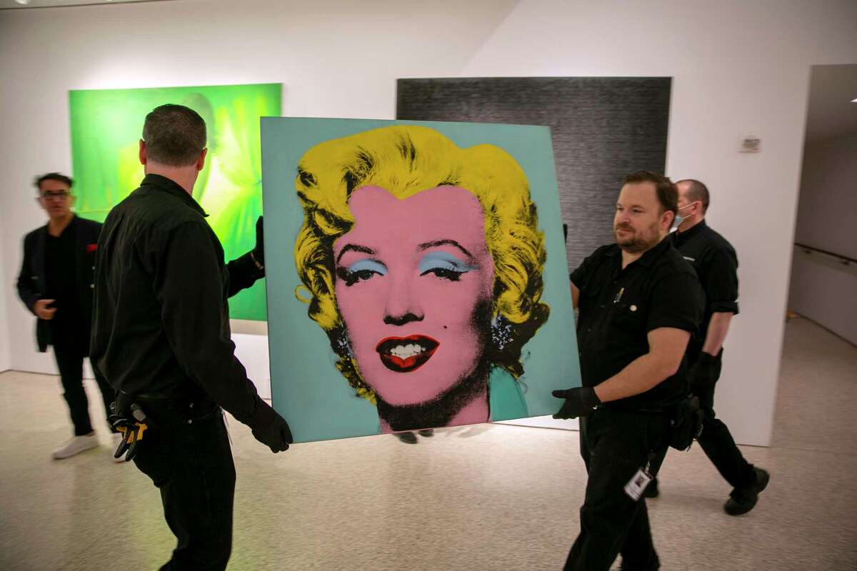 The 1964 painting Shot Sage Blue Marilyn by Andy Warhol is carried in Christie's showroom in New York City on Sunday, May 8, 2022. The auction house predicts it will sell for $200 million on Monday, becoming the most expensive 20th-century artwork to sell at auction.