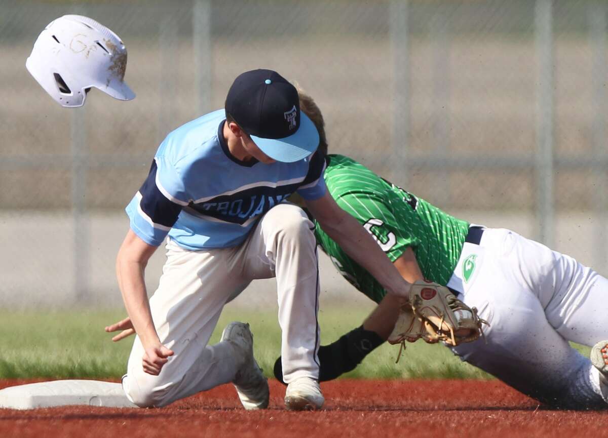 Carrollton's Grant Pohlman loses his helmet after colliding with a Triopia player on a stolen base attempt Monday.