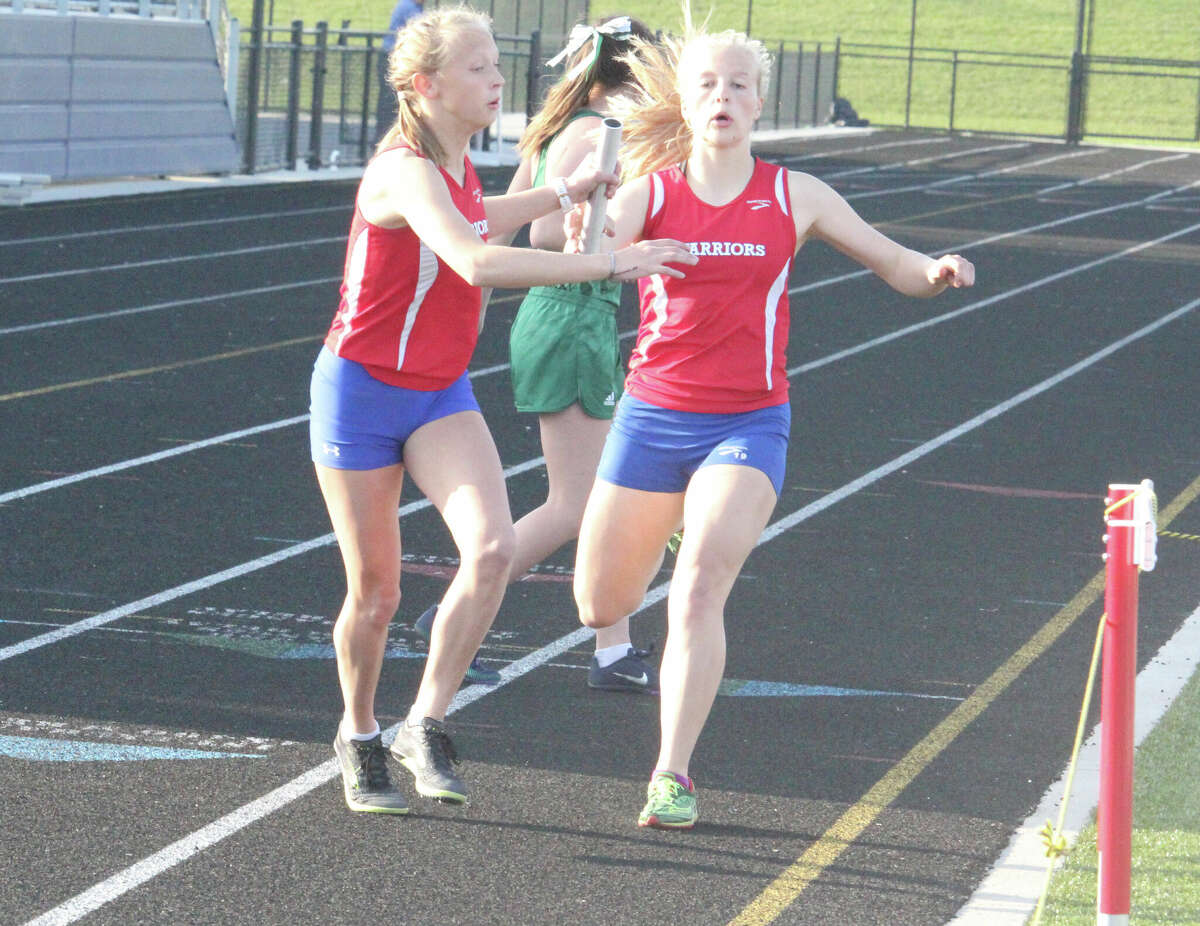 Chippewa Hills Natalie Gibson (left) takes the baton from Augusta Bowman during the 4x400 meter relay on Monday.