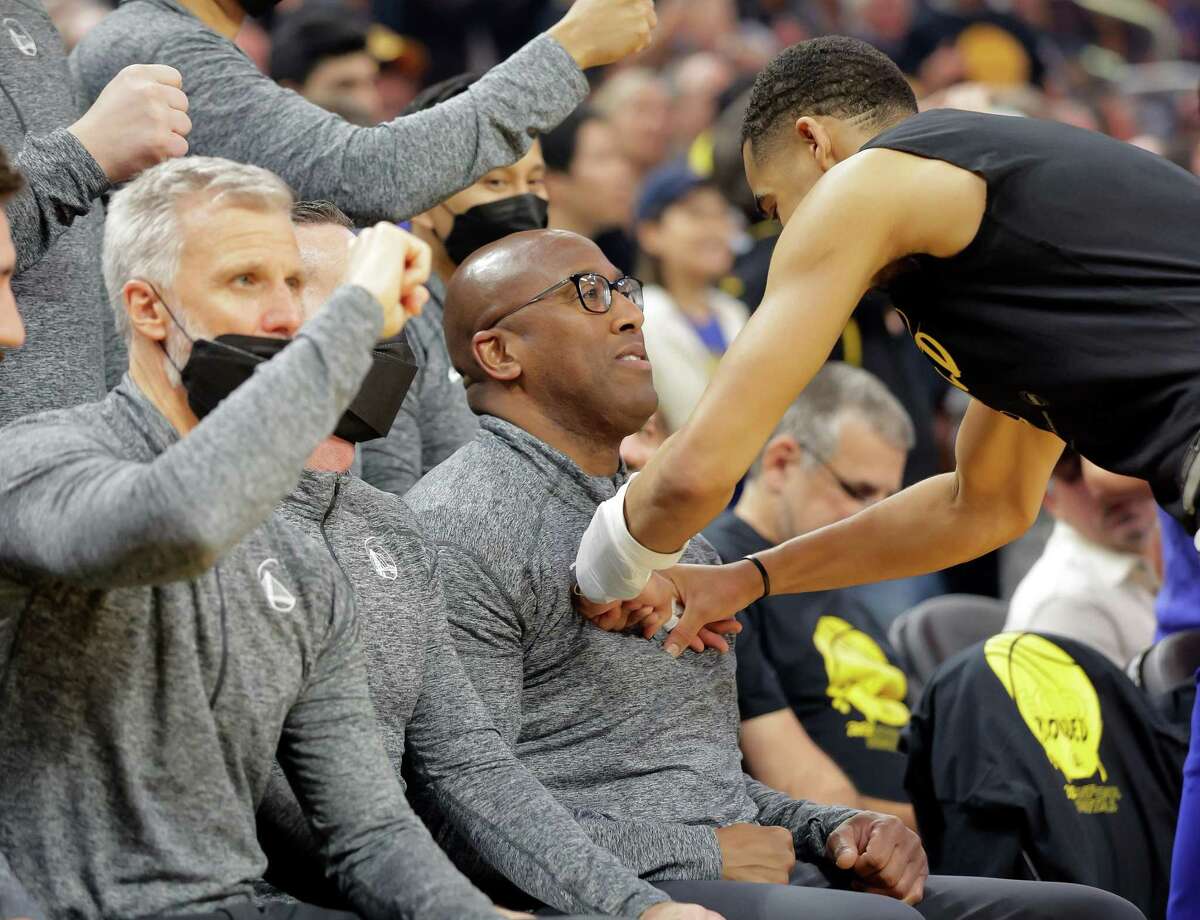 Jordan Poole (3) bumps Assistant coach Mike Brown on the chest as he takes the helm as Steve Kerr entered Covid protocols as the Golden State Warriors played the Memphis Grizzlies in Game 4 of the Western Conference Semifinals of the NBA Playoffs at Chase Center, in San Francisco, Calif., on Monday, May 9, 2022.