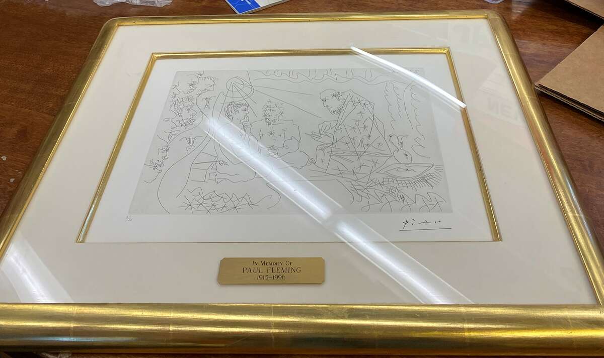 A framed etching by Pablo Picasso known as "Au théâtre: L'Astrologue (At the Theater: The Astrologer) (B. 1425, Ba. 1453)" is prepared for shipping at Jerseyville Public Library. The library included the etching in an April auction at Phillips gallery and auction house in New York.