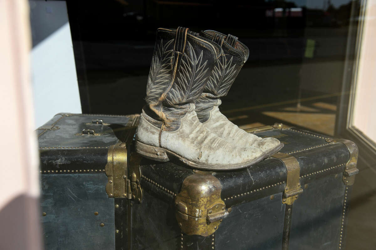 Cowboy boots and old suitcase in a store window in Texas.